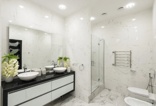 A luxurious bathroom with sleek marble stone flooring extending into the shower area.
