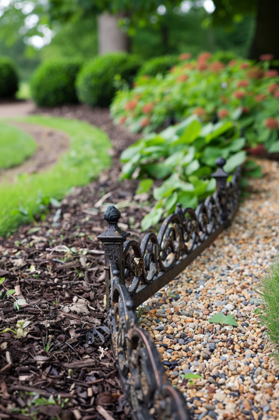 detailed shot of iron lawn edging enclosing a traditional English garden-