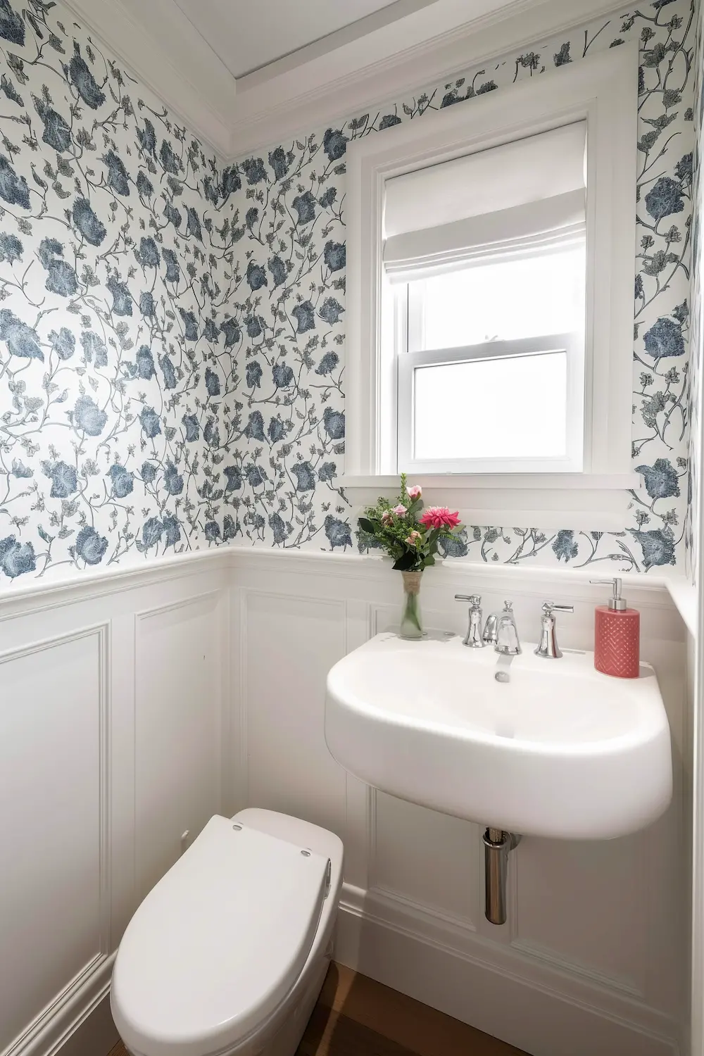 Bright bathroom with floral wallpaper modern sink and small vase of flowers on shelf