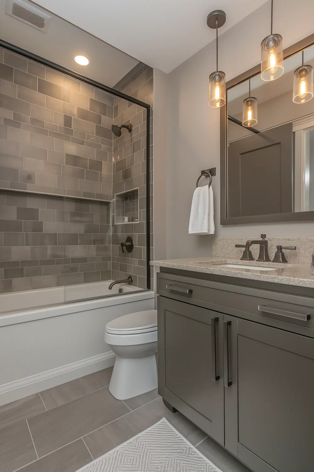 Modern bathroom with gray tiles a shower tub combo and stylish lighting fixtures