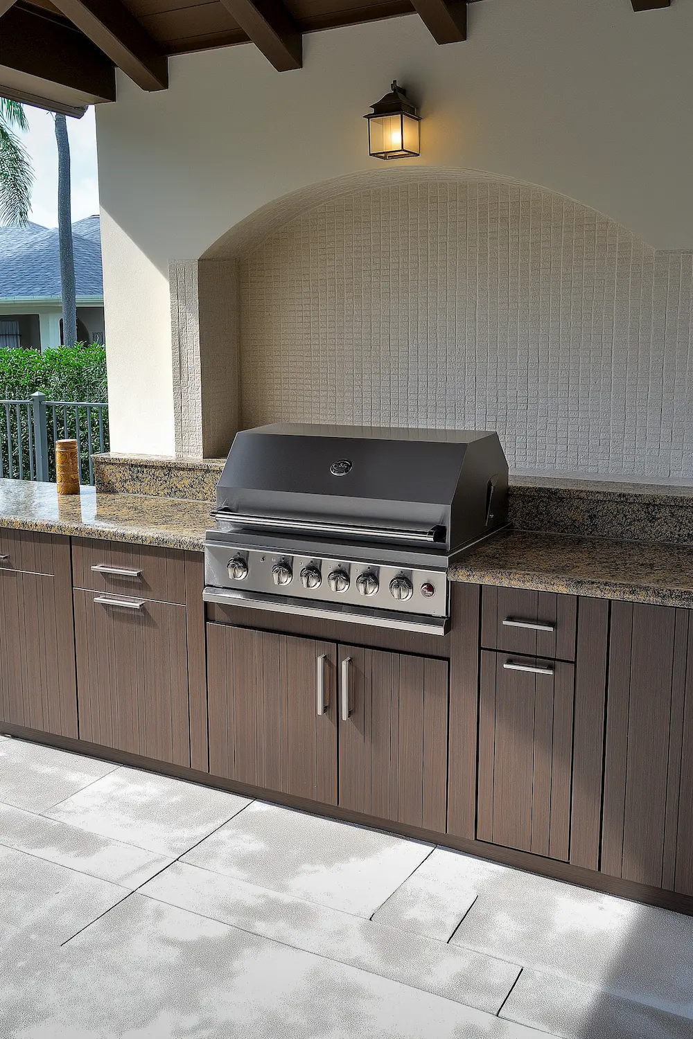 Chic outdoor kitchen with a stainless steel grill and wooden cabinetry