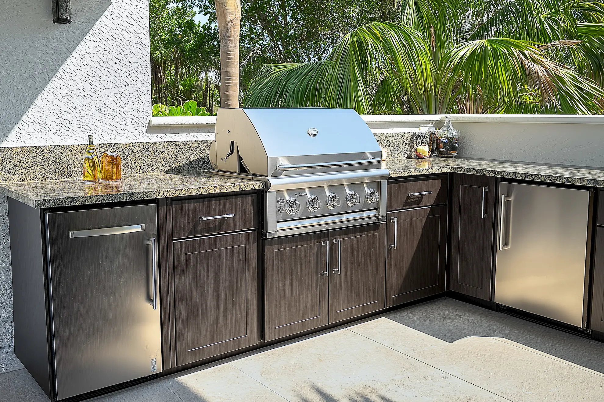 Stylish outdoor kitchen featuring a stainless steel grill and dark customized cabinetry